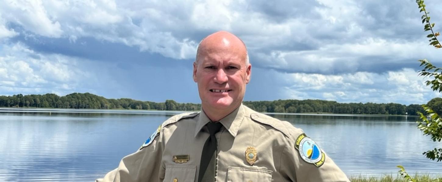 Park Manager Chris Raby stands in front of a lake