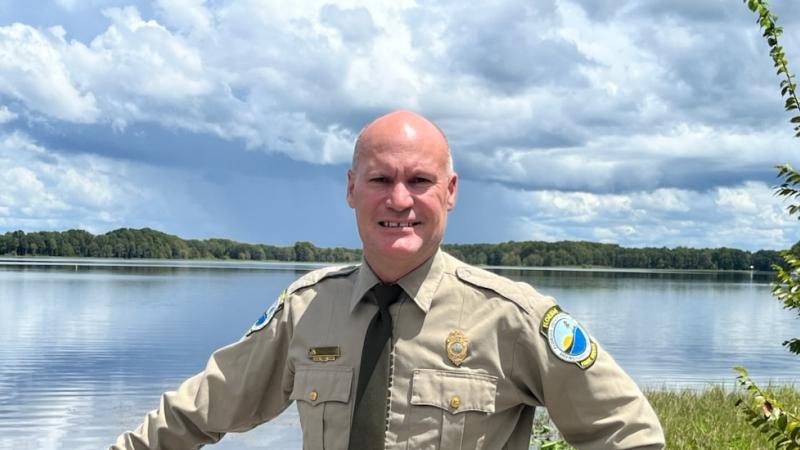 Park Manager Chris Raby stands in front of a lake